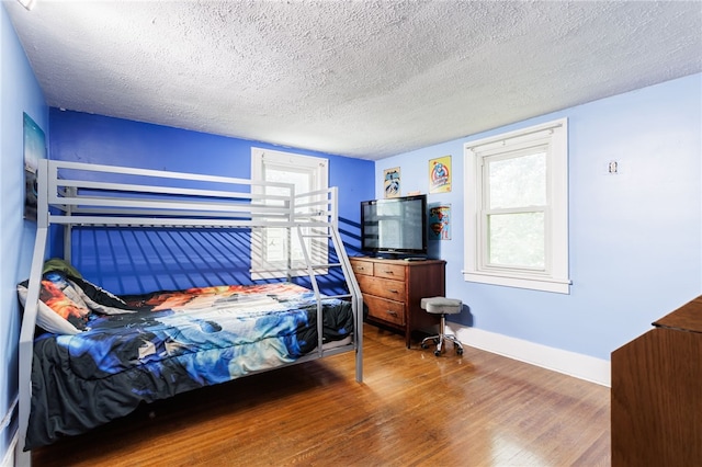 2092 Titus Ave, Irondequoit, NY 14622 - bedroom featuring wood finished floors, a textured ceiling, and multiple windows
