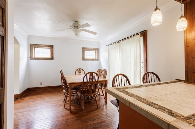2092 Titus Ave, Irondequoit, NY 14622 - dining area featuring crown molding, dark wood-style flooring, ceiling fan, and arched walkways