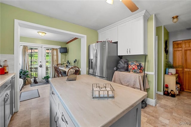 108 Phillips Rd, Syracuse, NY 13214 - kitchen featuring stainless steel fridge, white cabinets, french doors, light countertops, and a kitchen island