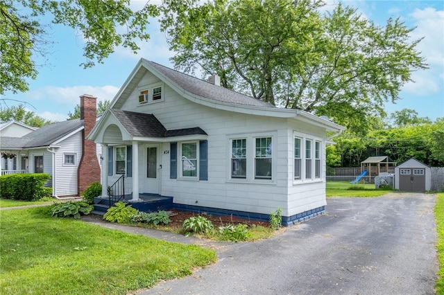 434 Crossfield Rd, Irondequoit, NY 14609 - bungalow-style home with a storage unit, driveway, and a shingled roof