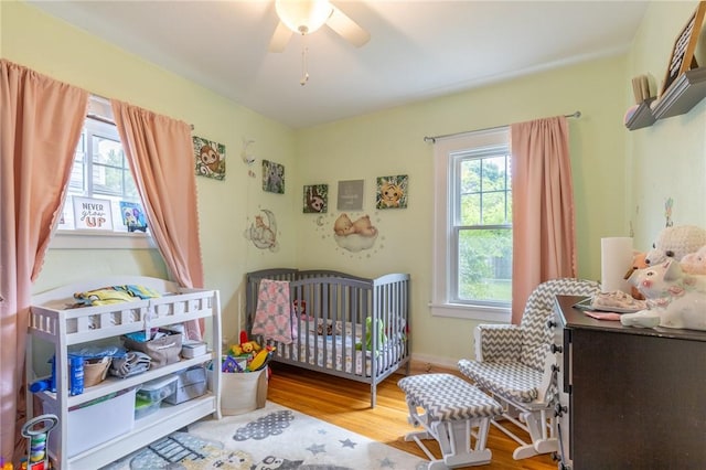 434 Crossfield Rd, Irondequoit, NY 14609 - bedroom featuring wood finished floors, a nursery area, and a ceiling fan
