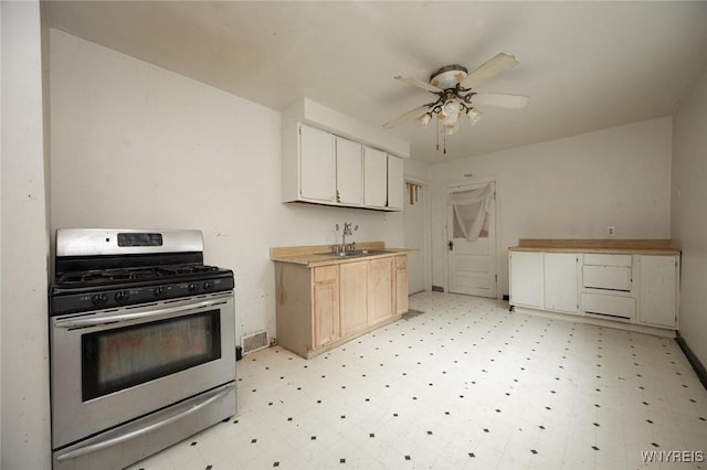 34 Schiller St, Buffalo, NY 14206 - kitchen with stainless steel gas range, light flooring, ceiling fan, white cabinets, and light countertops