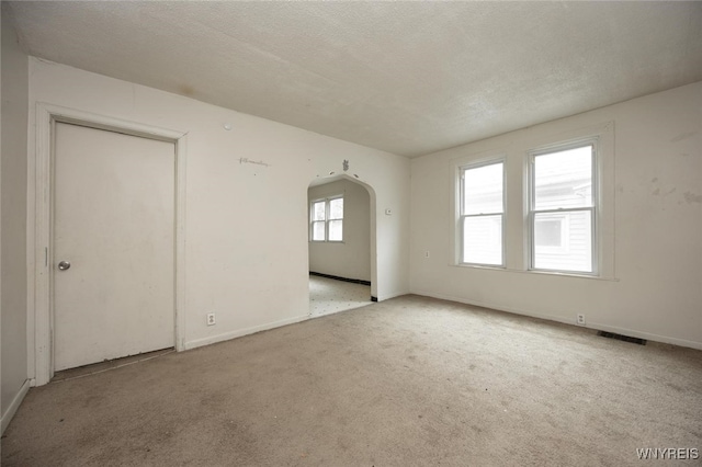 34 Schiller St, Buffalo, NY 14206 - empty room featuring arched walkways, carpet flooring, and a textured ceiling