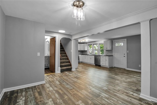 25 Cresthaven Dr, Cheektowaga, NY 14225 - unfurnished living room with stairs, wood finished floors, arched walkways, and crown molding
