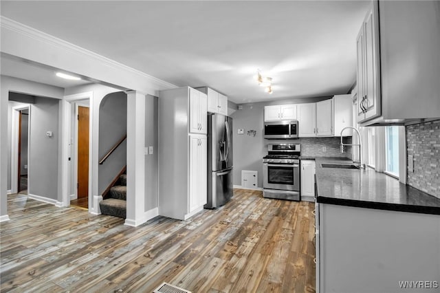 25 Cresthaven Dr, Cheektowaga, NY 14225 - kitchen featuring appliances with stainless steel finishes, light wood-style floors, decorative backsplash, and white cabinetry