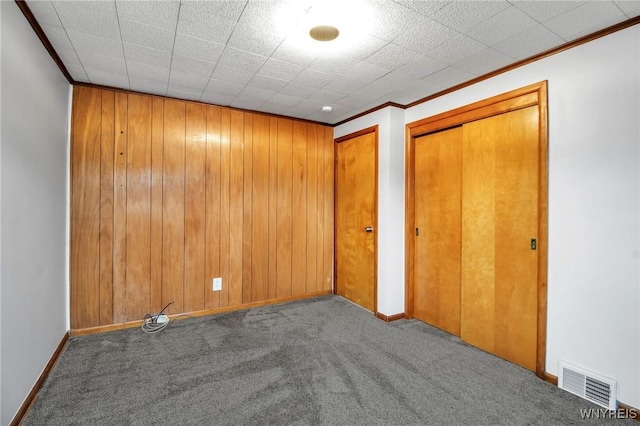 25 Cresthaven Dr, Cheektowaga, NY 14225 - unfurnished bedroom with carpet floors, two closets, ornamental molding, and wood walls