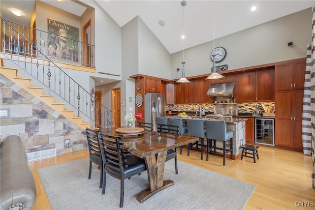 32 Coblesub Rd, West Monroe, NY 13036 - dining area with wine cooler, light wood finished floors, stairs, and high vaulted ceiling