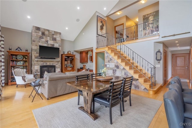 32 Coblesub Rd, West Monroe, NY 13036 - dining space featuring wood finished floors, stairway, high vaulted ceiling, and a fireplace