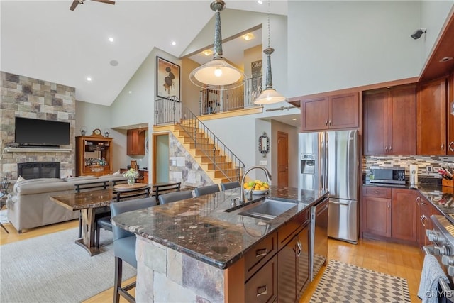 32 Coblesub Rd, West Monroe, NY 13036 - kitchen with stainless steel appliances, high vaulted ceiling, light wood-style flooring, a kitchen breakfast bar, and dark stone countertops