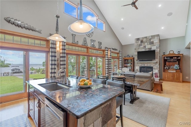 32 Coblesub Rd, West Monroe, NY 13036 - kitchen featuring dishwasher, a stone fireplace, high vaulted ceiling, a ceiling fan, and plenty of natural light