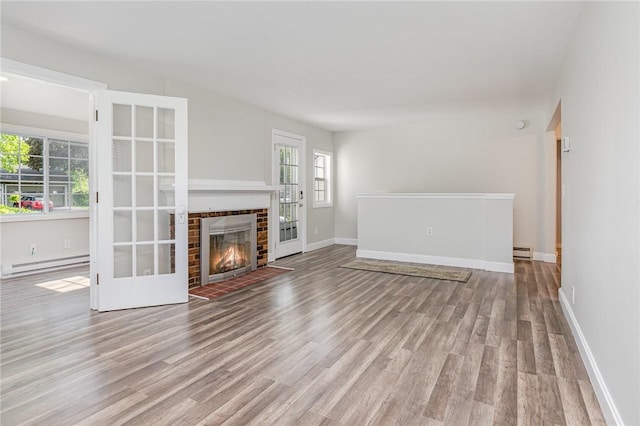 2761 Mount Read Blvd, Greece, NY 14616 - unfurnished living room with a baseboard radiator, wood finished floors, and a fireplace