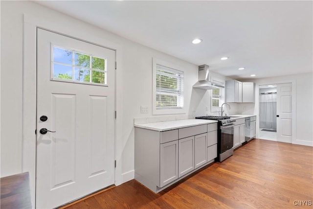7446 Collamer Rd, Manlius, NY 13057 - kitchen with stainless steel appliances, wall chimney exhaust hood, light countertops, wood finished floors, and recessed lighting