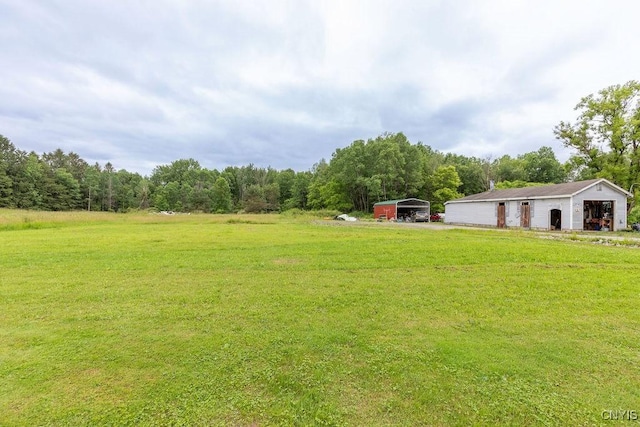 7446 Collamer Rd, Manlius, NY 13057 - view of green lawn featuring a carport, a wooded view, an outbuilding, and an outdoor structure