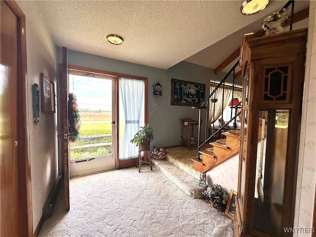 9718 Pearson Rd, Hartland, NY 14105 - carpeted foyer entrance with stairway, a textured ceiling, and lofted ceiling