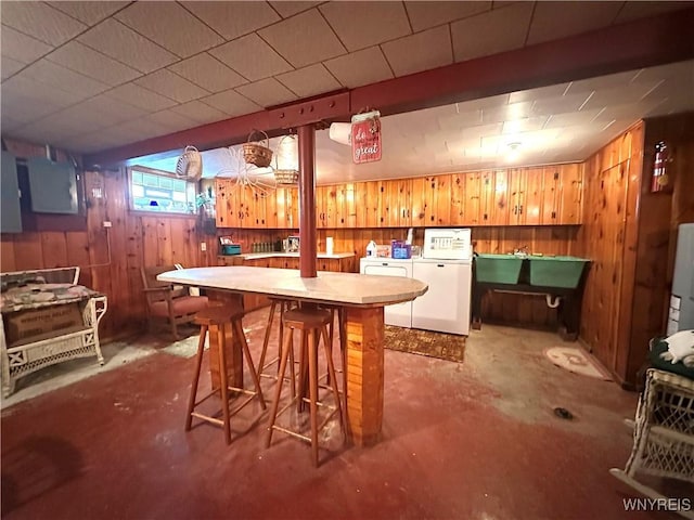 9718 Pearson Rd, Hartland, NY 14105 - bar area with wooden walls, unfinished concrete flooring, and independent washer and dryer