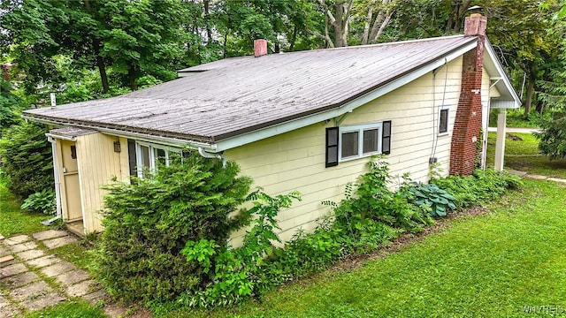711 Sandy Ave, Evans, NY 14006 - view of side of home with a chimney and a lawn