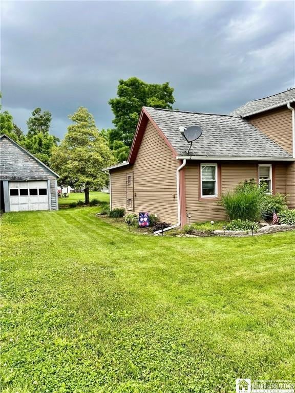 417 4th Ave, Olean-City, NY 14760 - view of side of home with a garage, a shingled roof, a lawn, and an outbuilding