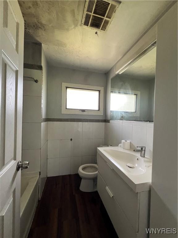 69 Steele Cir, Niagara, NY 14304 - full bath with tile walls, vanity, wood finished floors, and shower / bath combination