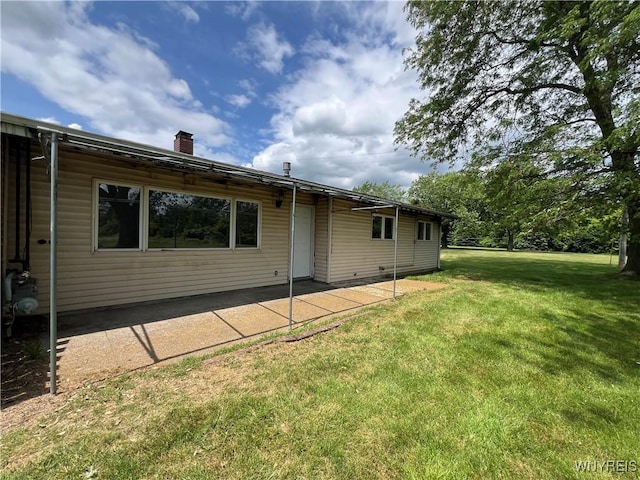 71 Steele Cir, Niagara, NY 14304 - back of property with a patio, a yard, and a chimney