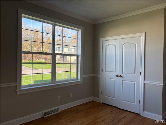 165 Shaker Hts, Camillus, NY 13031 - unfurnished bedroom featuring multiple windows, wood finished floors, crown molding, and a closet