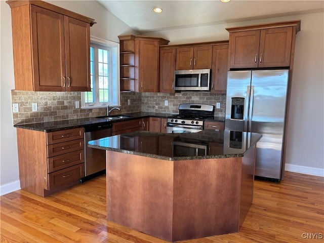 165 Shaker Hts, Camillus, NY 13031 - kitchen featuring stainless steel appliances, light wood-style flooring, tasteful backsplash, a kitchen island, and brown cabinets