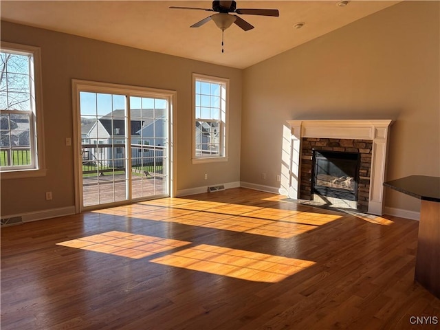 165 Shaker Hts, Camillus, NY 13031 - unfurnished living room with a ceiling fan, wood finished floors, a stone fireplace, and vaulted ceiling