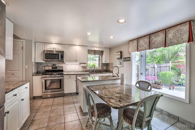 177 Foxpoint W, Amherst, NY 14221 - kitchen with stainless steel appliances, backsplash, white cabinets, recessed lighting, and dark stone countertops