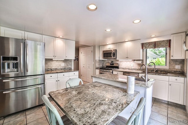 177 Foxpoint W, Amherst, NY 14221 - kitchen featuring stainless steel appliances, backsplash, white cabinets, light tile patterned floors, and recessed lighting