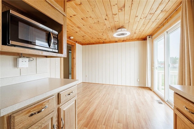 72 Juliane Dr, Gates, NY 14624 - kitchen with stainless steel microwave, wooden ceiling, light countertops, light wood-type flooring, and wood walls