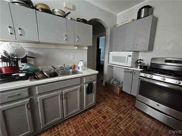 283 Genesee Park Dr, Syracuse, NY 13224 - kitchen with stainless steel gas stove, white microwave, gray cabinets, brick patterned floors, and ornamental molding