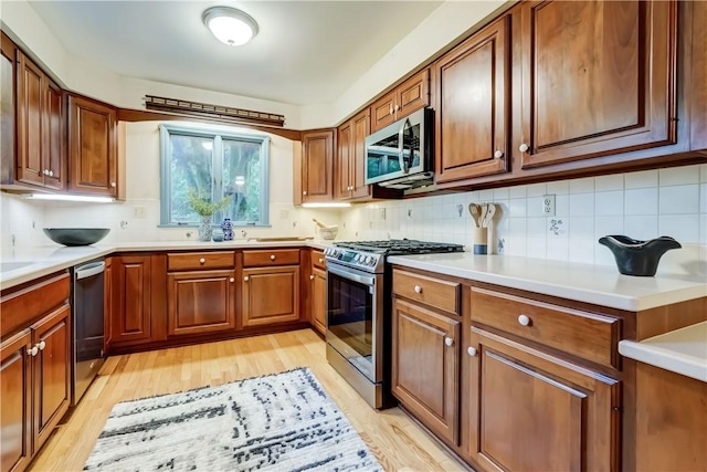 107 Fieldston Ter, Brighton, NY 14610 - kitchen with stainless steel appliances, tasteful backsplash, light wood finished floors, and brown cabinetry