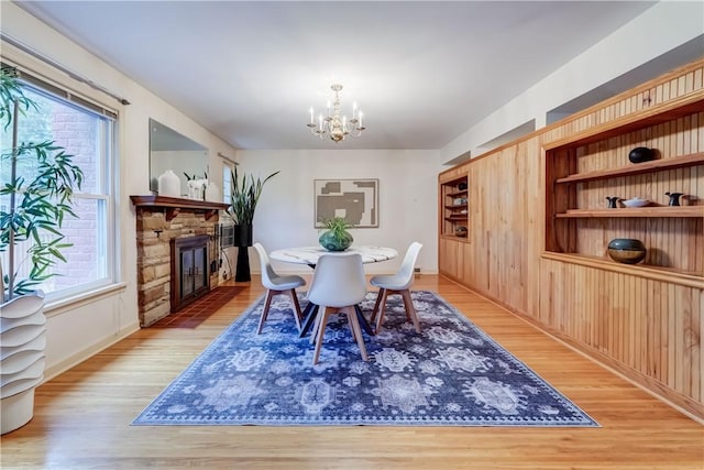 107 Fieldston Ter, Brighton, NY 14610 - dining room featuring a chandelier, light wood-type flooring, and a fireplace