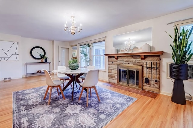 107 Fieldston Ter, Brighton, NY 14610 - dining space featuring a chandelier, wood finished floors, and a fireplace