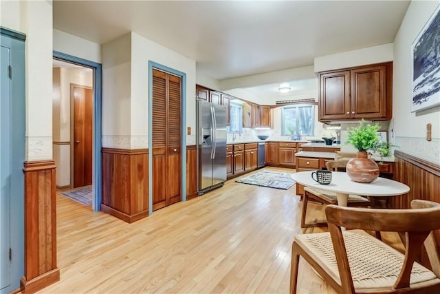 107 Fieldston Ter, Brighton, NY 14610 - kitchen featuring appliances with stainless steel finishes, light wood finished floors, wainscoting, light countertops, and brown cabinets