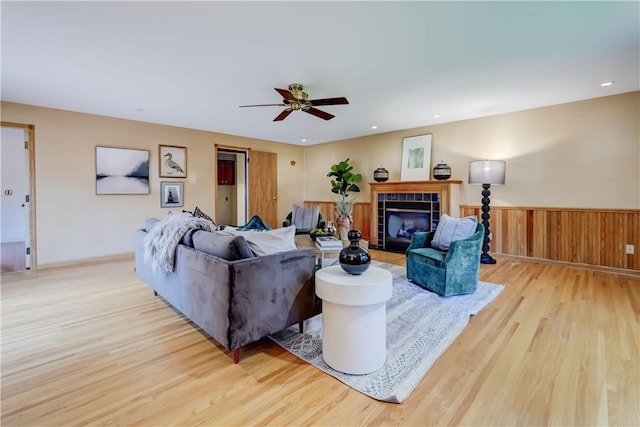 107 Fieldston Ter, Brighton, NY 14610 - living room featuring wood finished floors, a ceiling fan, a wainscoted wall, and a tile fireplace