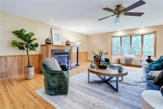 107 Fieldston Ter, Brighton, NY 14610 - living area featuring wood finished floors, a tiled fireplace, a ceiling fan, and wainscoting