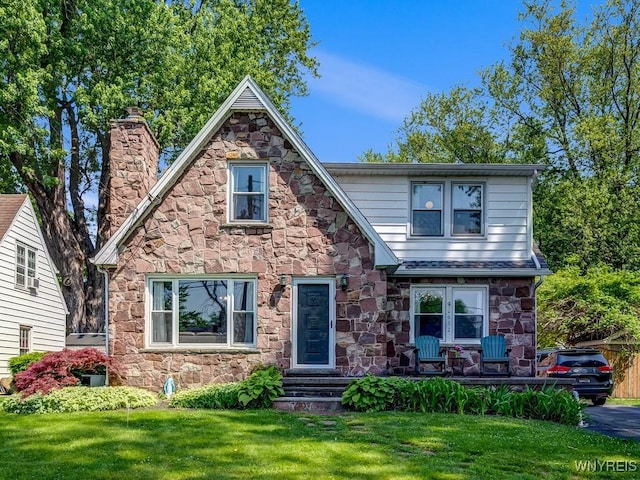 8652 Griffon Ave, Niagara Falls, NY 14304 - tudor house featuring stone siding, a chimney, and a front yard