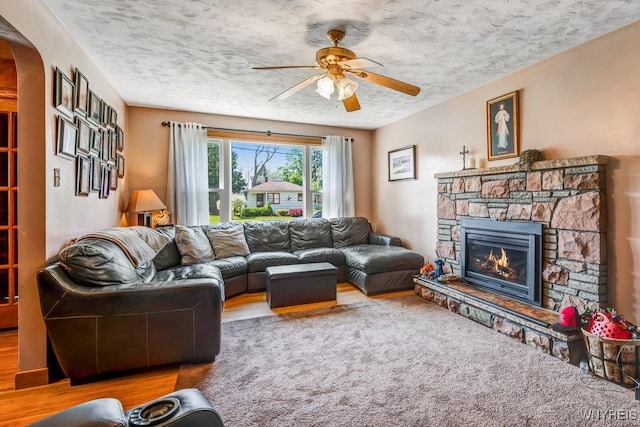 8652 Griffon Ave, Niagara Falls, NY 14304 - living area featuring ceiling fan, a fireplace, a textured ceiling, wood finished floors, and arched walkways
