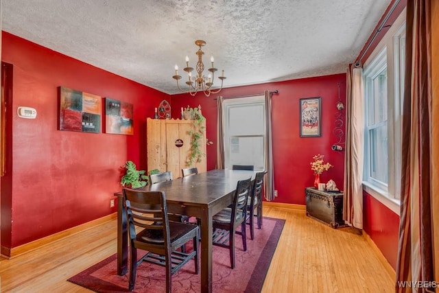 8652 Griffon Ave, Niagara Falls, NY 14304 - dining area with a chandelier, light wood-style floors, and a textured ceiling