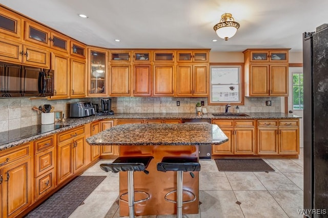 8652 Griffon Ave, Niagara Falls, NY 14304 - kitchen featuring appliances with stainless steel finishes, decorative backsplash, brown cabinets, a breakfast bar area, and recessed lighting