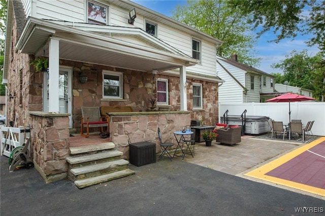 8652 Griffon Ave, Niagara Falls, NY 14304 - back of house featuring a hot tub, stone siding, a patio, and outdoor dining area