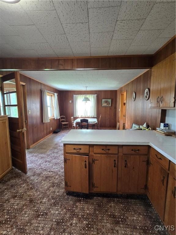 7412 State Highway 51, Plainfield, NY 13491 - kitchen featuring a peninsula, brown cabinetry, light countertops, wooden walls, and open floor plan