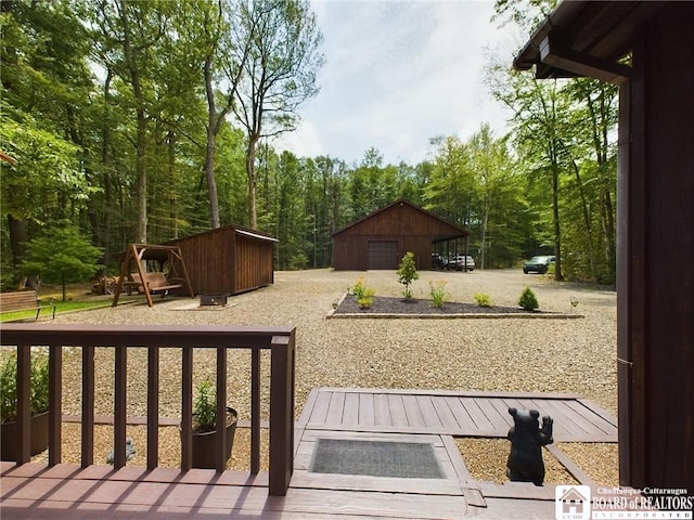 56 Heather Ln, Bradford, PA 16701 - wooden deck with a detached garage, an outdoor structure, and driveway