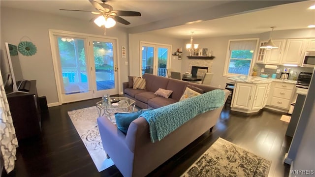 41 Maple Ave, Hamburg, NY 14075 - living area with dark wood-type flooring, ceiling fan, a stone fireplace, and a chandelier