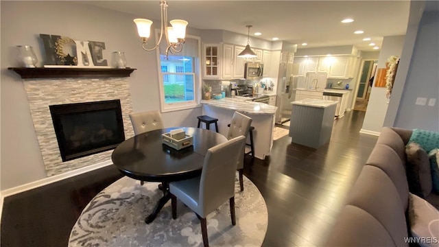 41 Maple Ave, Hamburg, NY 14075 - dining space with dark wood-style floors, a chandelier, recessed lighting, and a stone fireplace