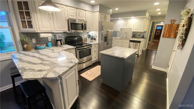 41 Maple Ave, Hamburg, NY 14075 - kitchen featuring appliances with stainless steel finishes, a peninsula, light stone counters, dark wood-type flooring, and white cabinets
