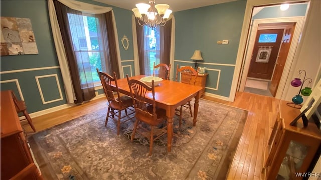 41 Maple Ave, Hamburg, NY 14075 - dining area with wood finished floors, a chandelier, a wainscoted wall, and a decorative wall