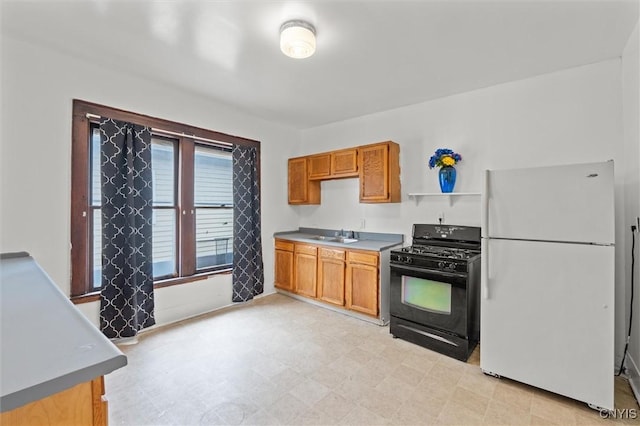 905-07 Tallman St, Syracuse, NY 13204 - kitchen featuring freestanding refrigerator, black range with gas cooktop, light flooring, and brown cabinets