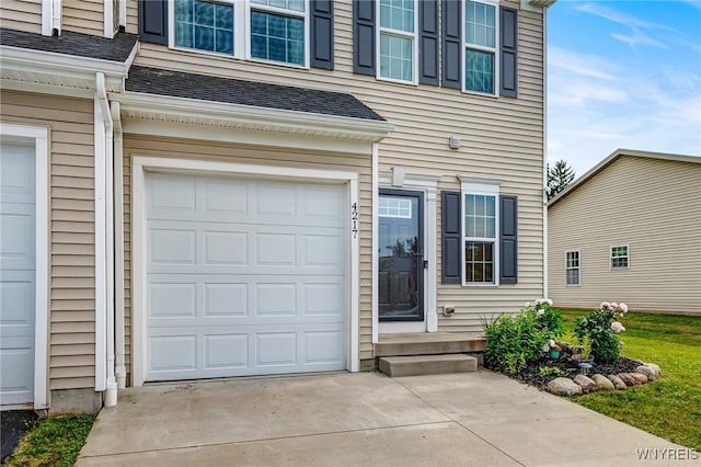 4217 Arthur Ct, Hamburg, NY 14075 - doorway to property with an attached garage, concrete driveway, and a shingled roof