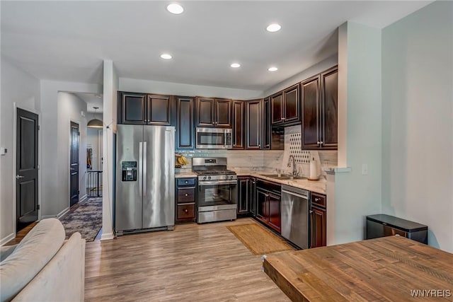 4217 Arthur Ct, Hamburg, NY 14075 - kitchen featuring appliances with stainless steel finishes, light wood finished floors, tasteful backsplash, recessed lighting, and dark brown cabinetry
